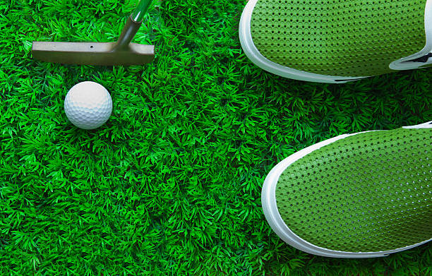 istock golf ball and putter on green field 512325953