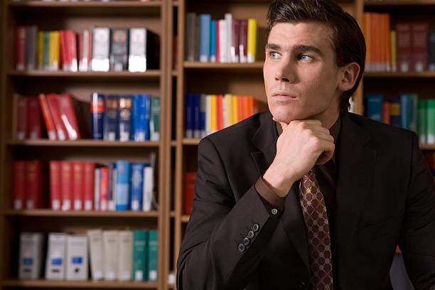 istock Pensive Man In Shirt And Tie At Library 512326205