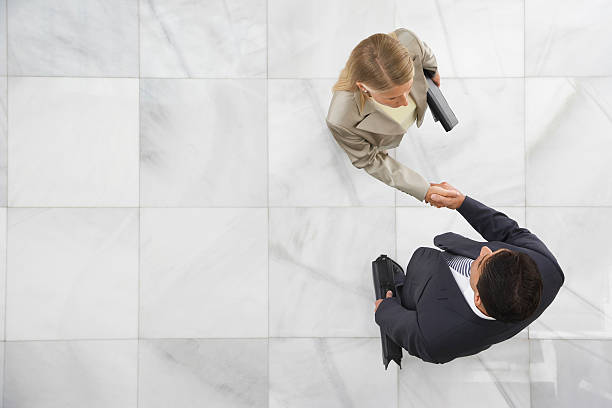 istock Two Businesspeople Shaking Hands In Lobby 512326223
