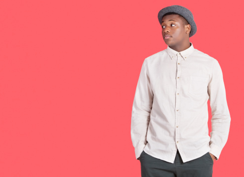 Young African American man looking sideways over red background