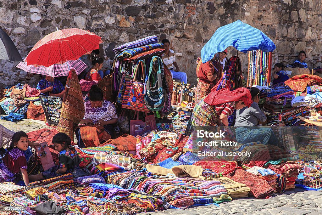 The indigenous people of Antigua, Guatemala Antigua, Guatemala. December 01, 2013: Maya people dressed in traditional clothes with bright colors, yarn-based textiles that are woven into capes, shirts, blouses, huipiles and dresses sell Fabrics traditional market streets of Antigua Guatemala Guatemala Stock Photo