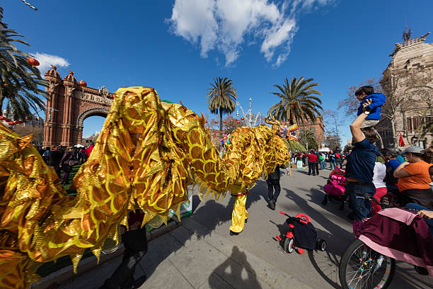 Barcelona Barcelona, Spain - February 13, 2016: This picture shows the dance of the yellow dragon among people enjoying at the ceremony of Chinese New Year 2016 in Barcelona near Arc de Triomf. arc de triomf barcelona photos stock pictures, royalty-free photos & images