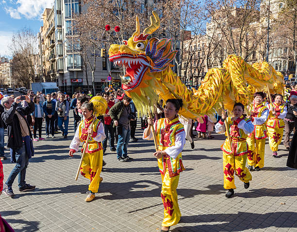 Barcelona Barcelona, Spain - February 13, 2016: The dance of the yellow dragon among people enjoying at the ceremony of Chinese New Year 2016 in Barcelona near Arc de Triomf. arc de triomf barcelona photos stock pictures, royalty-free photos & images