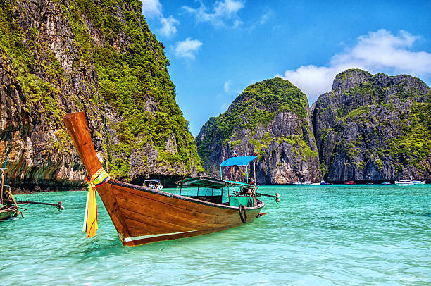 longtail boat de madera en maya bay, tailandia - phuket province beach blue cliff fotografías e imágenes de stock