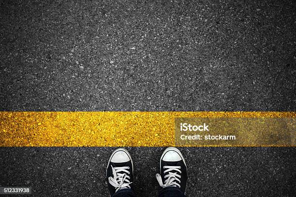 Personas En Una Línea Amarilla Inicial De Asfalto Foto de stock y más banco de imágenes de Línea de salida - Línea de salida, Principios, Viaje