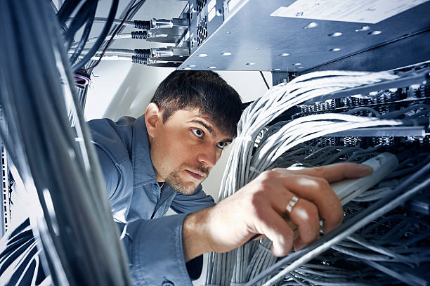 Technician engeneer is checking server's wires in data center Technician engeneer (30-35) is checking server's wires in data center computer connector stock pictures, royalty-free photos & images