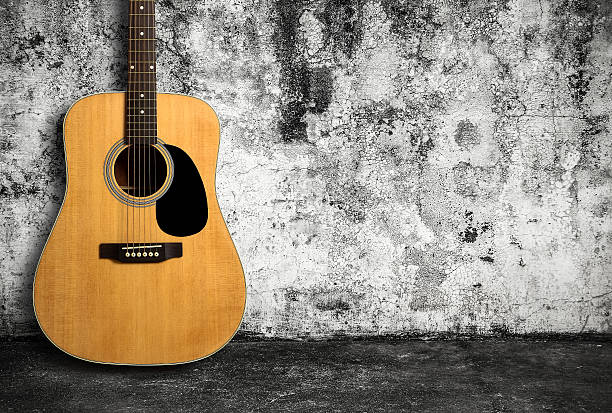 istock Acoustic guitar against old wall 512335618