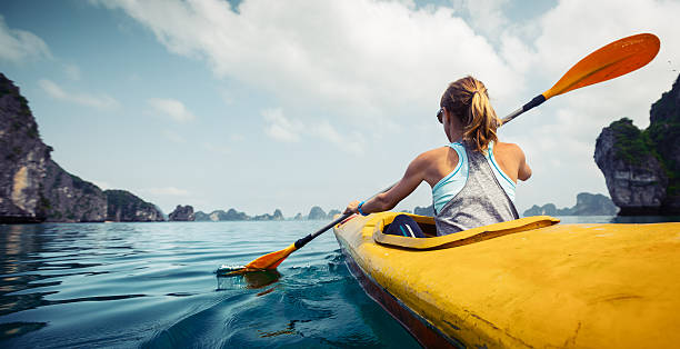 Kayaking Woman exploring calm tropical bay with limestone mountains by kayak. Ha Long Bay, Vietnam using a paddle stock pictures, royalty-free photos & images