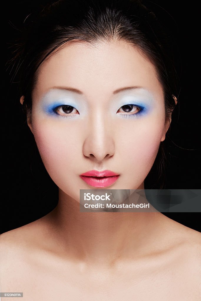 Asian model with colorful makeup. Cosmetic beauty image. Isolated on black. Perfect skin.  Blue Eyeshadow Stock Photo