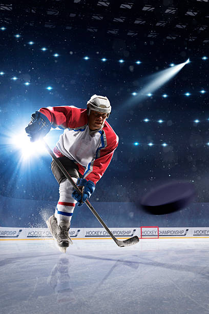 Ice hockey player on the ice arena Ice hockey player on the ice arena in lights hockey puck photos stock pictures, royalty-free photos & images