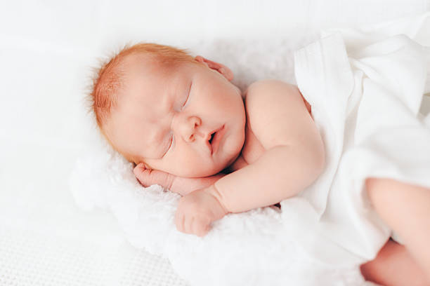 istock sleeping newborn baby in a wrap 512341084