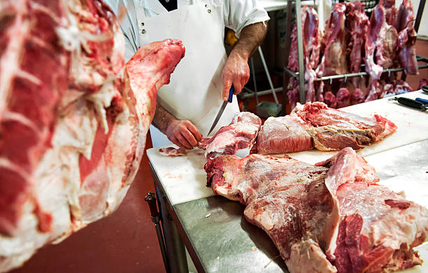 istock Butcher cutting pieces of meat 512341404