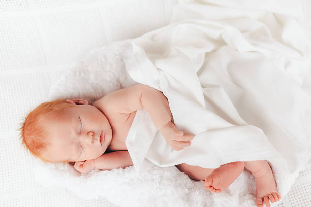 istock sleeping newborn baby in a wrap 512341518