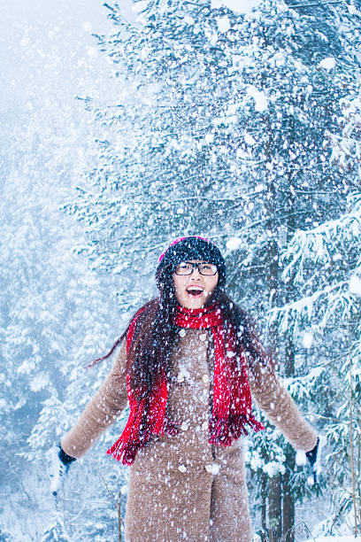 istock Young woman playing with snow in winter forest 512346702