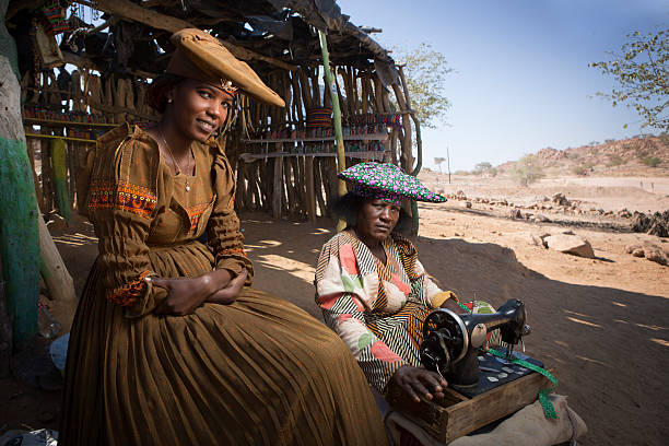Herero women Usakos, Namibia. - August 7, 2015: Herero women proudly displays her traditional Herero outfit. The Herero women adopted this way of dressing after being German colonials settled in South West Africa. The herringbone hats are said to be the Herero's own adaptation as they wanted a hat thet represented their cattle which are a large part of their culture. kaokoveld stock pictures, royalty-free photos & images