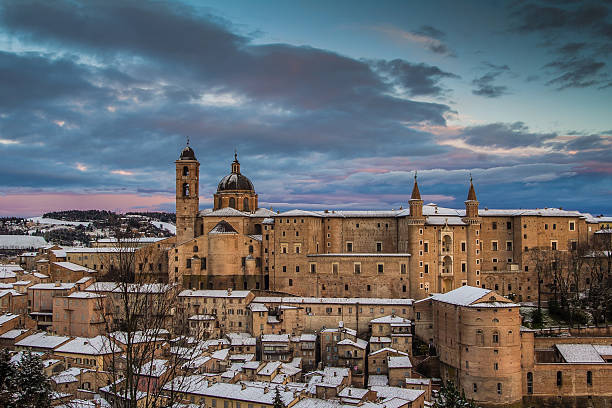 istock Colored sky over Urbino at sunset with snow. 512349014