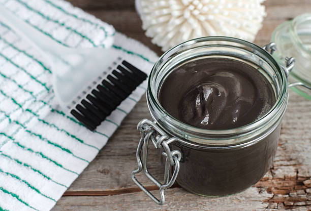 Black volcanic cosmetic clay in a glass jar