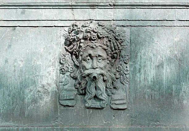 Dry marble fountain with a sculpture of a bearded man's face