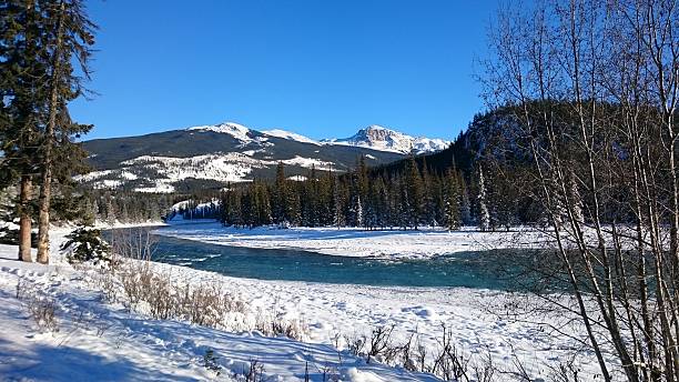 istock Snowy scene with mountains and a stream 512353660