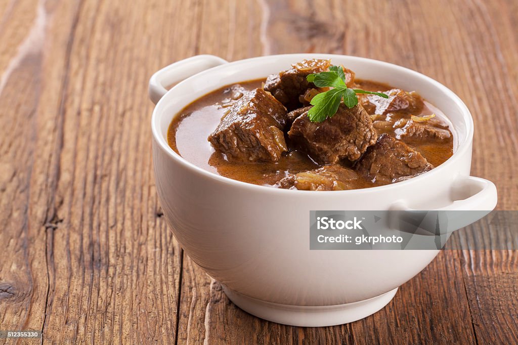 Beef stew served with bread Beef stew served with bread in a plate on a wooden background Cooking Pan Stock Photo