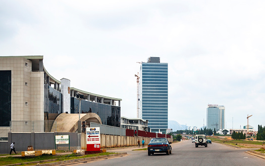 Abuja, Nigeria - September 4, 2015: Traffic passing government buildings in the streets of Nigeria's capital city downtown.