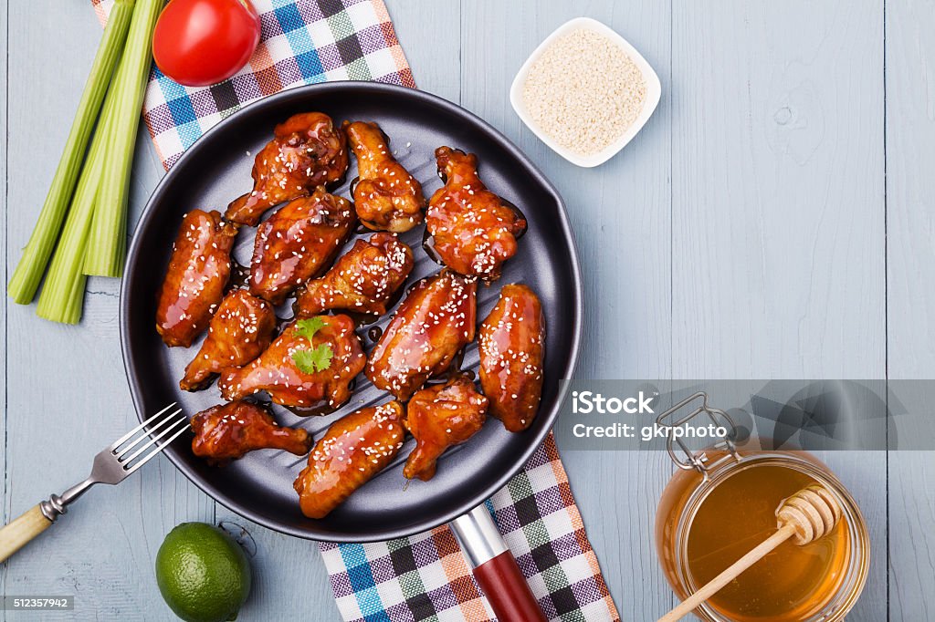 Baked chicken wings in honey sauce sprinkled with sesame seeds. American Culture Stock Photo