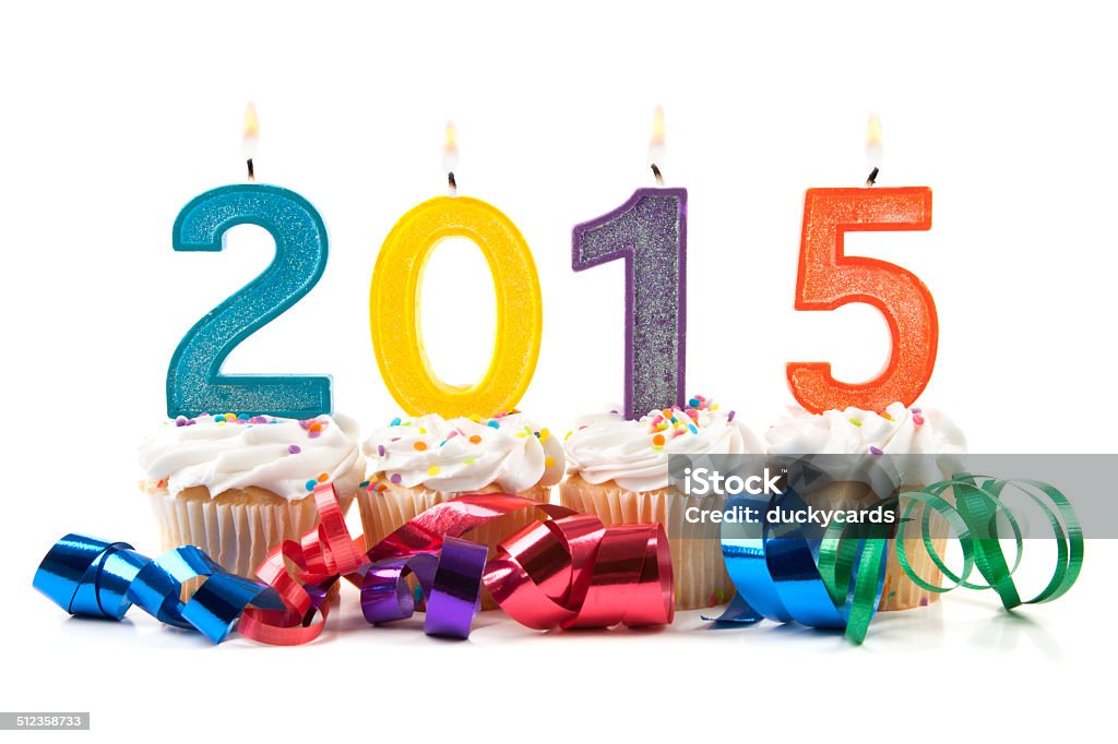 Happy New Year 2015 Candles and Cupcakes Lit candles on white cupcakes with frosting for the new year 2015. 2015 Stock Photo