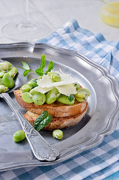 Toasted bread topped with broad beans, Italian. stock photo
