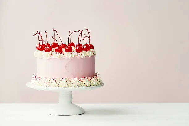 Cake decorated with frosting and maraschino cherries
