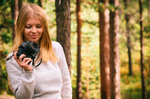 Young Woman with retro photo camera outdoor hipster Lifestyle forest nature on background