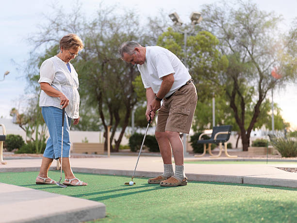 casal sênior jogando minigolfe - senior couple golf retirement action - fotografias e filmes do acervo