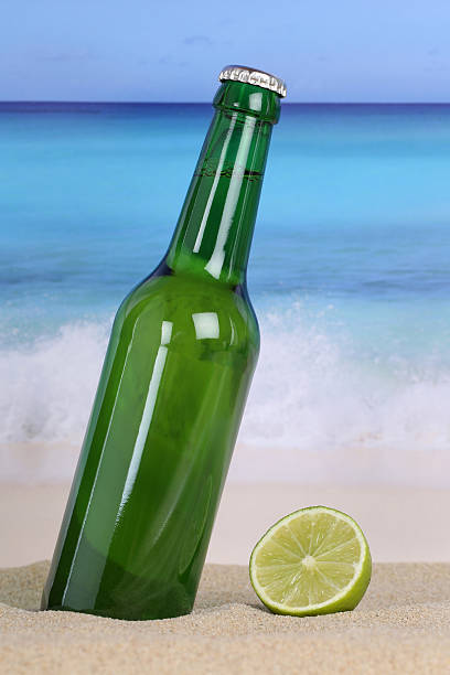 istock Beer in green bottle on the beach and sea 512385579