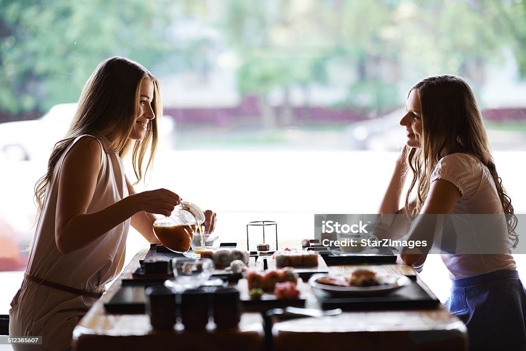 Taking the time to catch up Shot of two young women at an asian restaurant togetherhttp://www.azarubaika.com/iStockphoto/2014_05_24_Vika&Sasha.jpg Pouring Stock Photo