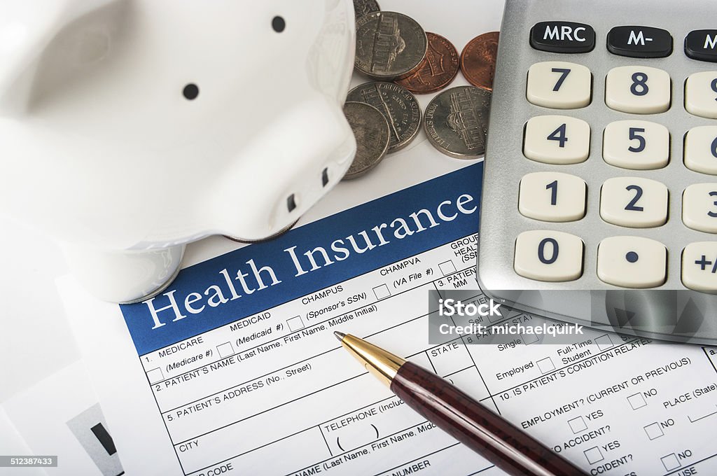 Health insurance form with piggy bank Health insurance form with piggy bank, calculator and coins Accidents and Disasters Stock Photo