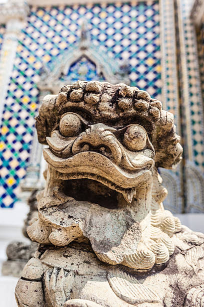 Chinese Dog carving Chinese dog or lion sculpture in Wat Phra Kaew, Temple of the Emerald Buddha, Bangkok, Thailand. chinese temple dog stock pictures, royalty-free photos & images