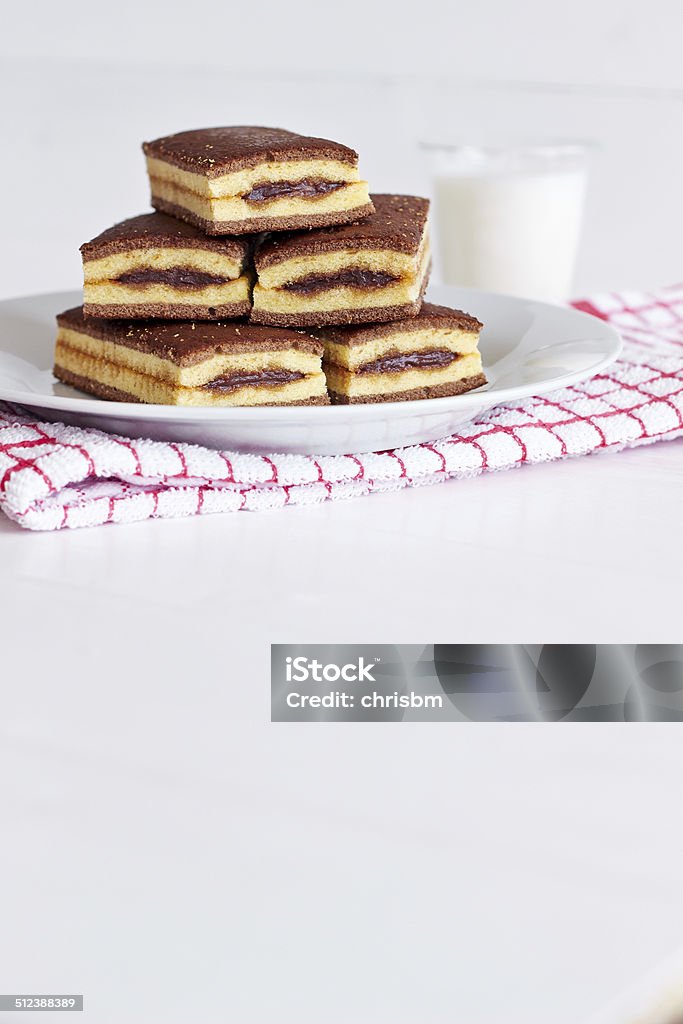 Chocolate cream cakes on white plate with glass of milk Chocolate cream cakes on white plate with glass of milk, on a white wooden table with space for text Backgrounds Stock Photo