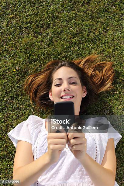 Frau Entspannt Auf Dem Grassms Auf Einem Smartphone Stockfoto und mehr Bilder von Zusehen