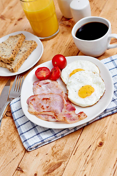 istock Breakfast with fried eggs and bacon on wooden table 512389291