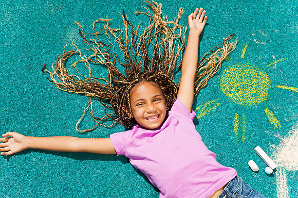 hermosa chica negra con su chalked dibujo - little girls sidewalk child chalk fotografías e imágenes de stock