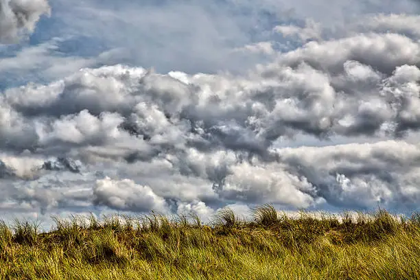 HDR stormy cloudscape and grass dune