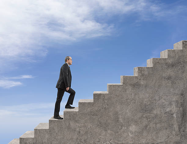 istock Businessman Walking Up the Big Staircase 512400400