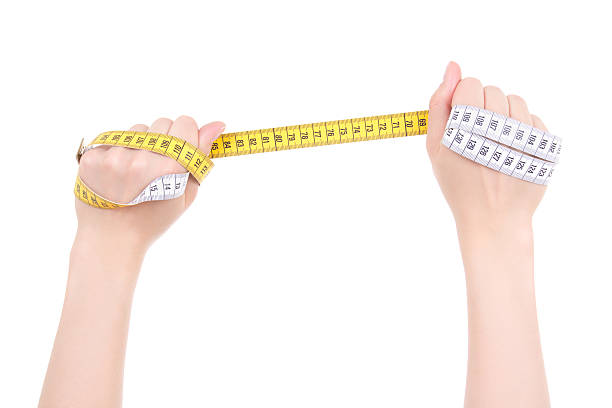 istock hands holding yellow measure tape isolated on white background 512401252