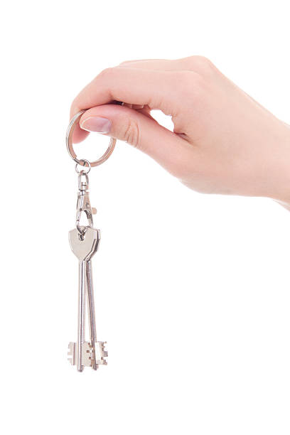 istock woman hand holding keys isolated on white 512401794