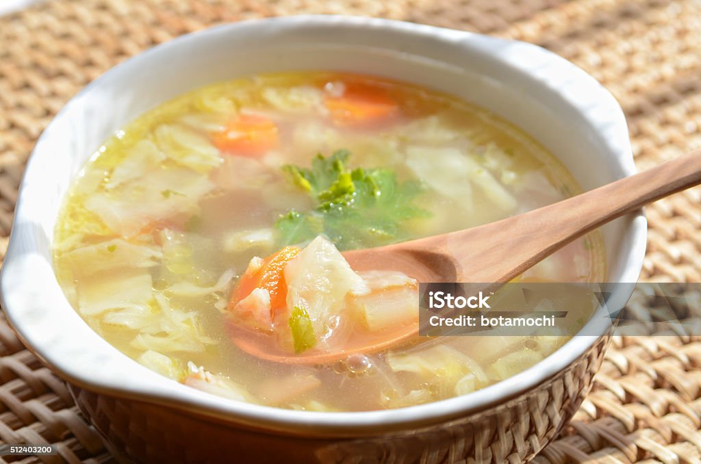 vegetable clear soup vegetable clear soup with wooden spoon on wooden table Bacon Stock Photo