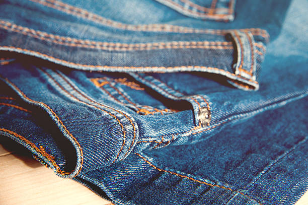 istock Blue jeans on old wooden background 512405180