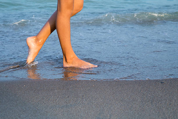 istock young woman legs on the beach at sunset 512409504