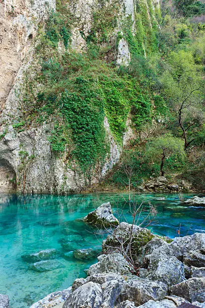 A natural landmark in the french department Vaucluse, Provence-Alpes-Cote d'Azur, Southern France. The biggest spring of france. Clear turquoise fresh water with rocks in the background. Near the little town L'Isle-sur-la-Sorgue. In the near famous travel destinations like Avignon, Gordes, Roussillon.