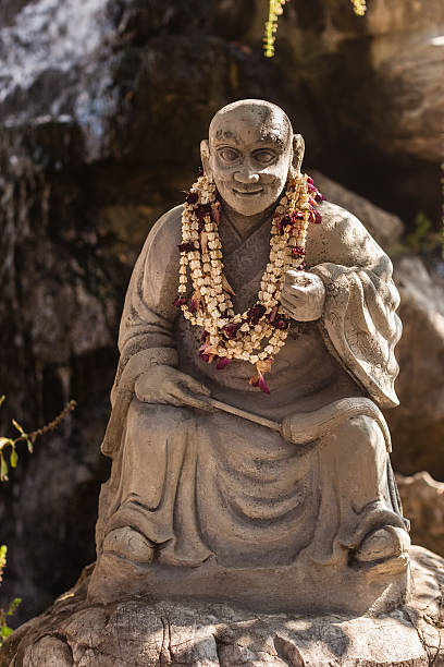 Buddhist monk sculpture statue of a wise chinese or buddhist mong in a zen garden in the Wat Pho Temple, Thailand laughing buddha garden statue stock pictures, royalty-free photos & images