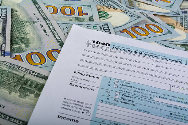 istock Tax Form 1040 and Hundred Dollar Bills 512422747