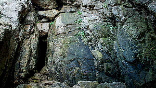 istock Dark entrance into a granite cave 512423117
